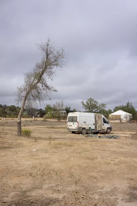 A small transporter besides a tree at an ecovillage