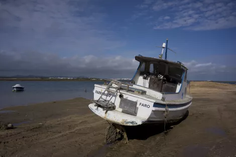 A boat at the beach of Faro, Portugal, during low tide
