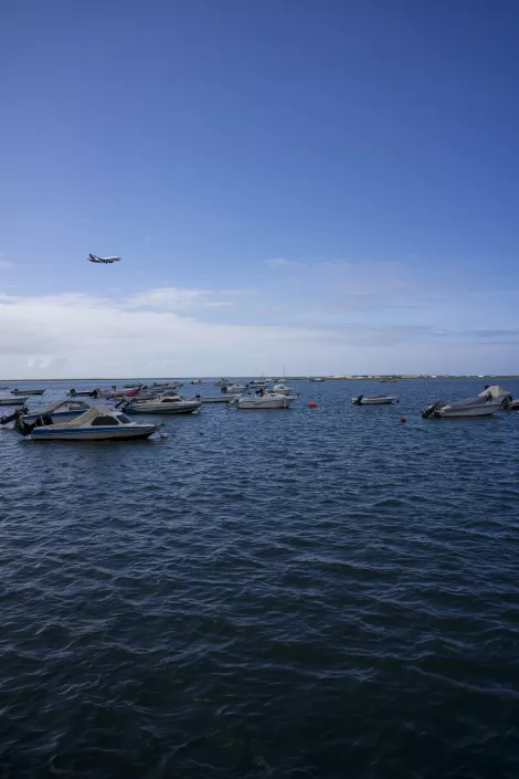 the blue sea and a plane during landing at Faro Airport, Portugal