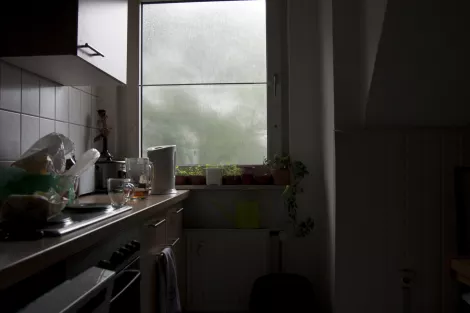 A kitchen with a view during a rainy day
